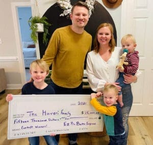 family holds giant prize after winning bathroom giveaway